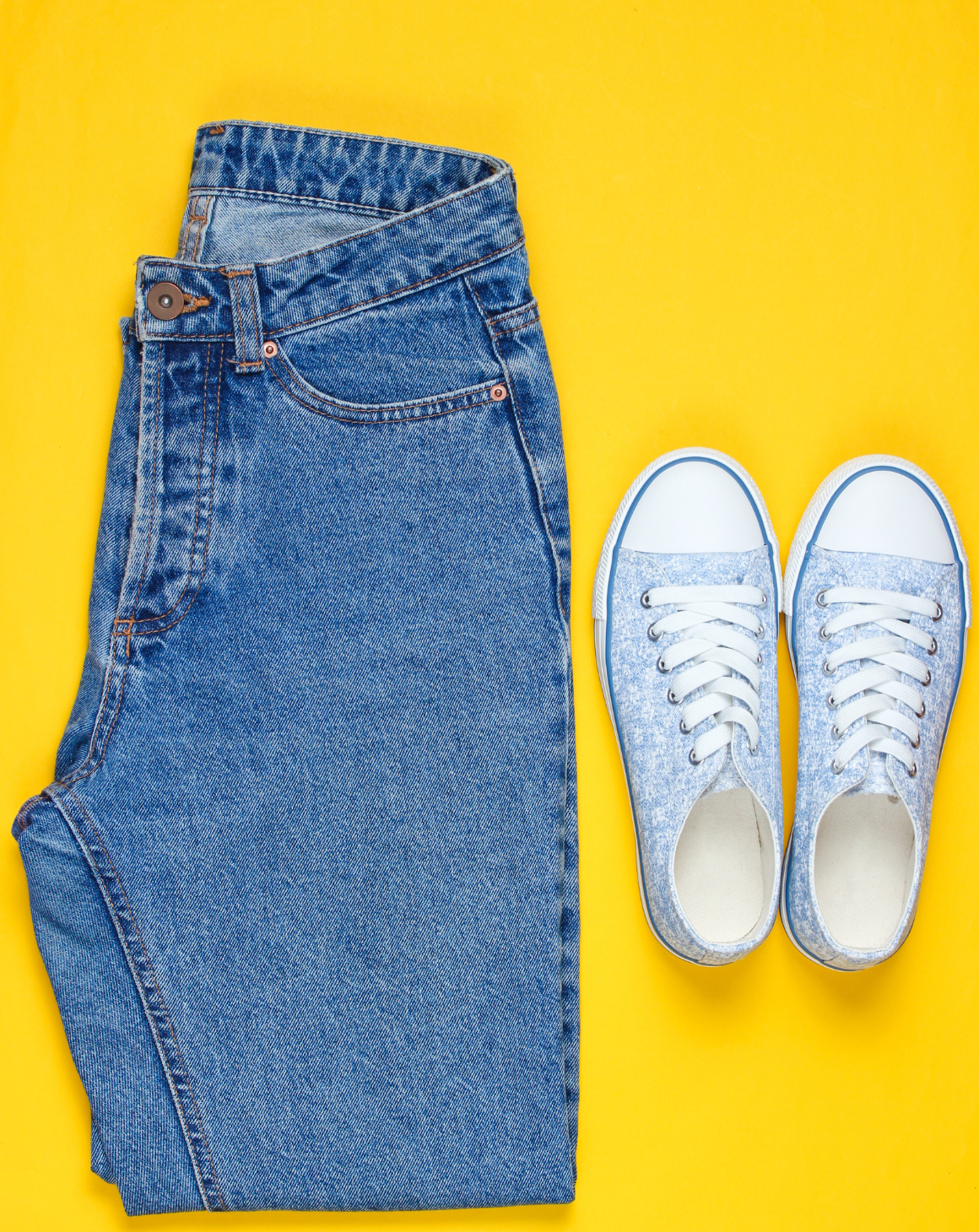 A pair of jeans and sneakers on a yellow background 