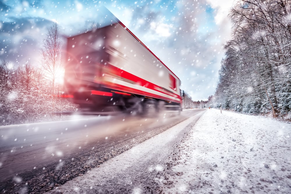 semi truck driving on snowy highway