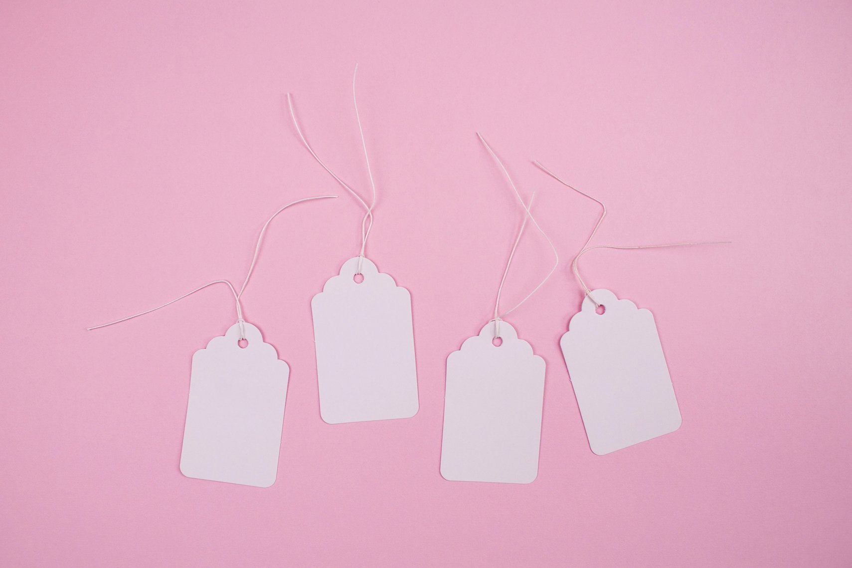 White paper tags on pink background