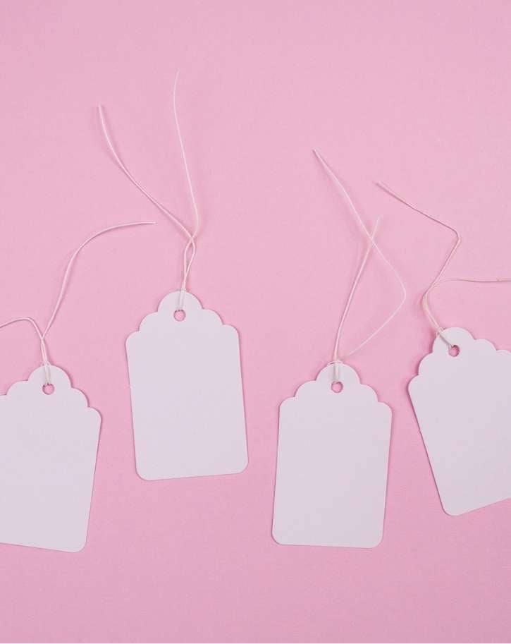 White paper tags on pink background