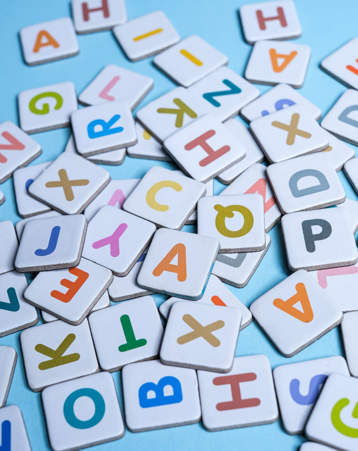 A collection of alphabet letters on white cards on a blue floor for Amazon Strategies