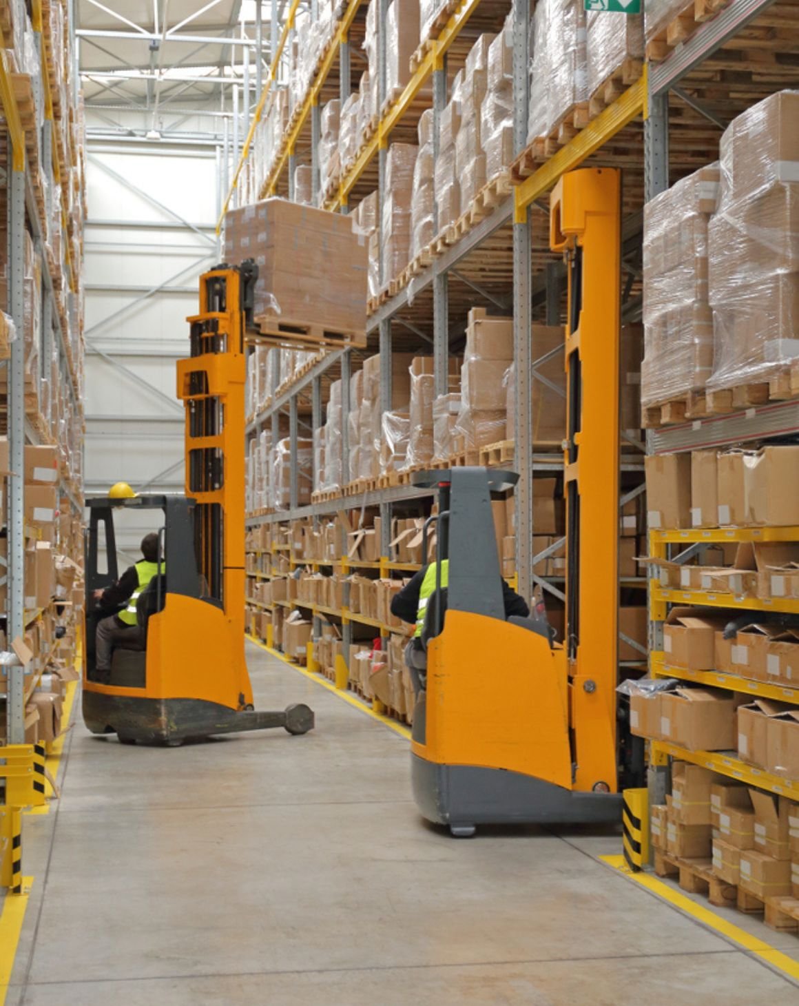 fork lifts picking up boxes in a warehouse