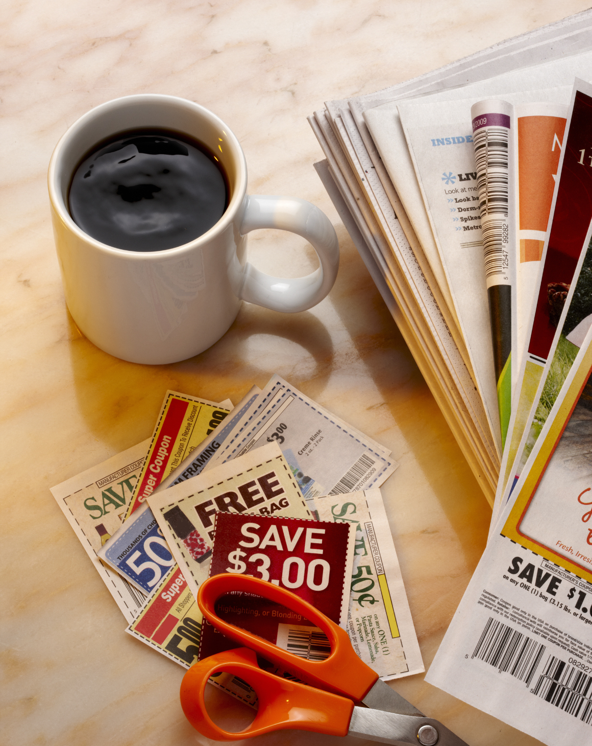 stack of coupons + cup of coffee on a table