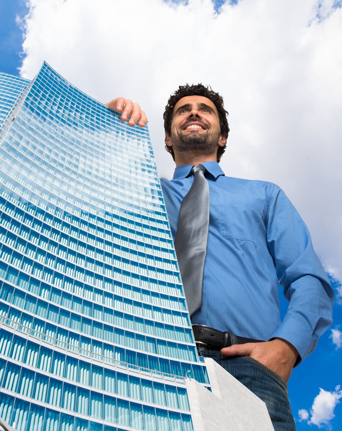 a big man standing next to a tall building 