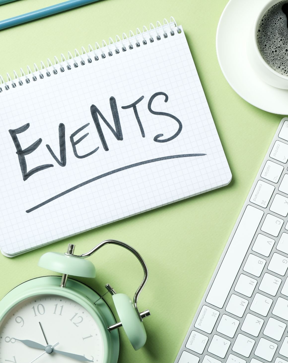 A notepad displaying events alongside a coffee cup and a keyboard, representing a focused and organized work environment.