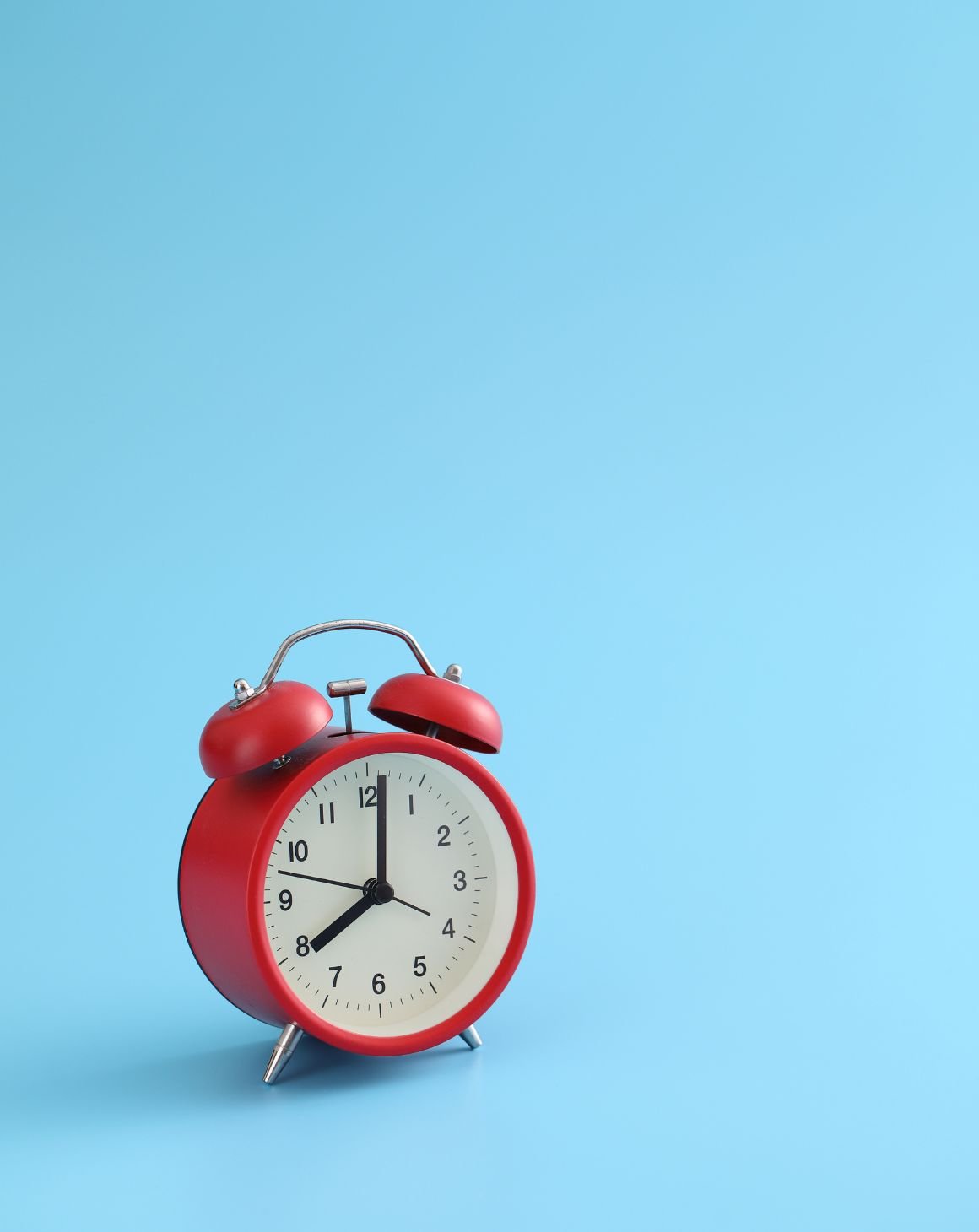 red alarm clock with blue background